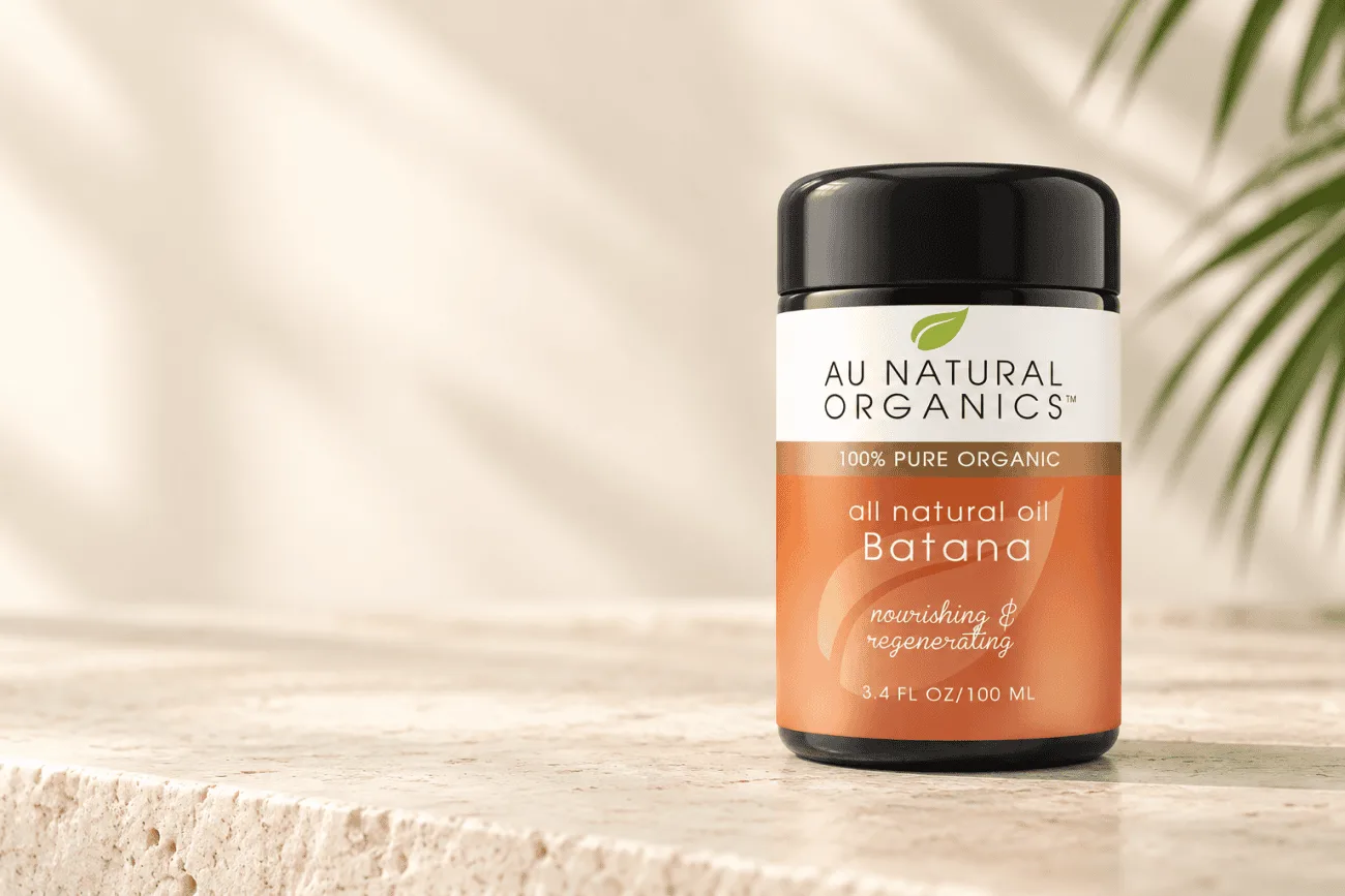 Au Natural Organics Batana oil jar on pale limestone with soft botanical shadows